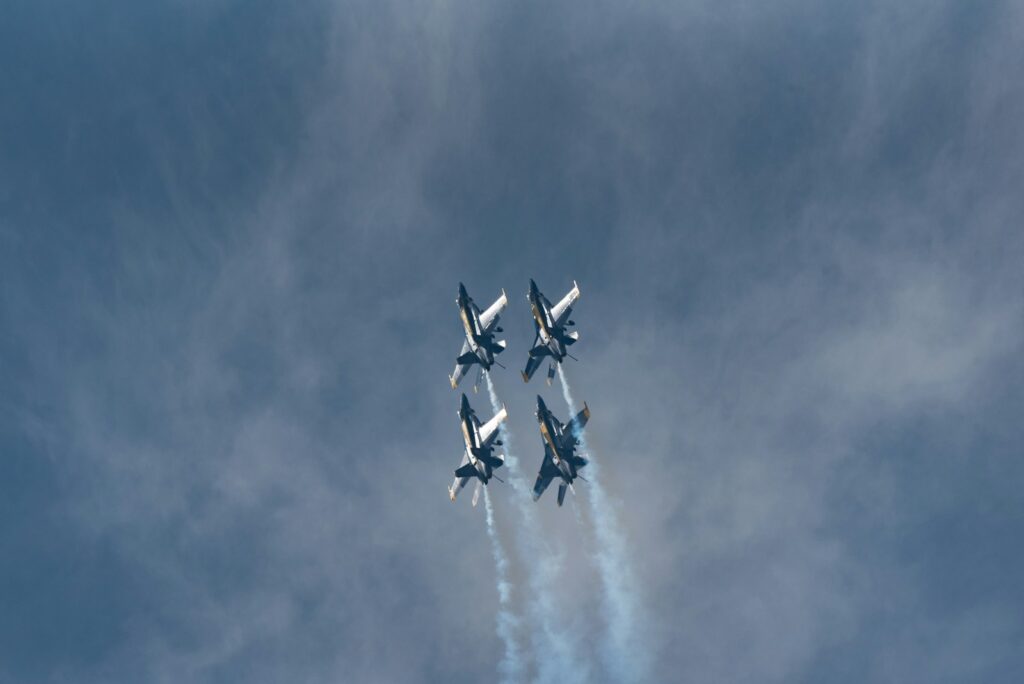 a group of fighter jets flying through a cloudy sky